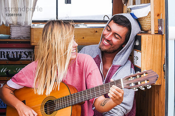 Junges Paar  verliebt in die Gitarre im Transporter
