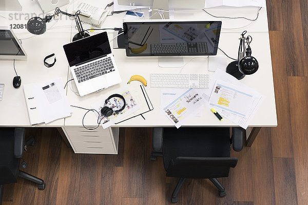 Schreibtische mit PCs im hellen und modernen Großraumbüro