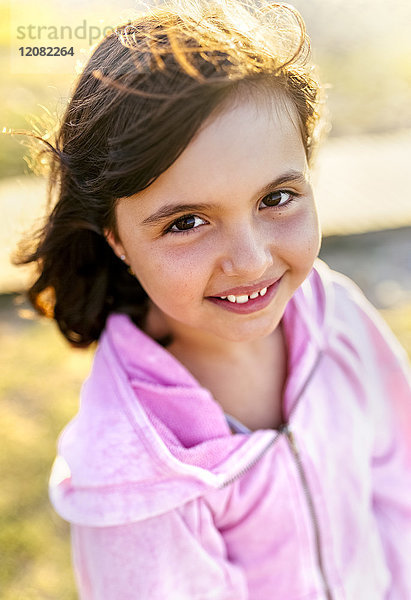 Porträt eines lächelnden kleinen Mädchens mit blasenden Haaren