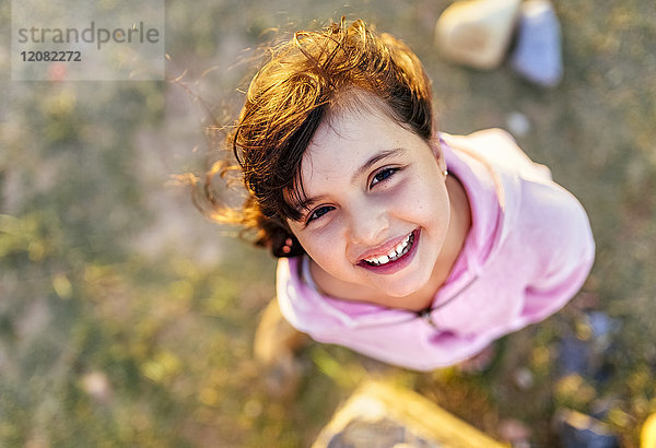 Porträt eines lächelnden kleinen Mädchens mit blasenden Haaren