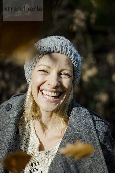 Porträt einer glücklichen Frau im Wald im Herbst