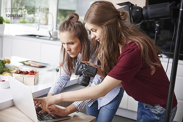 Blogger mit Laptop und Kamera in der Küche