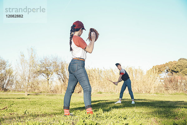 Junges Paar spielt Baseball im Park