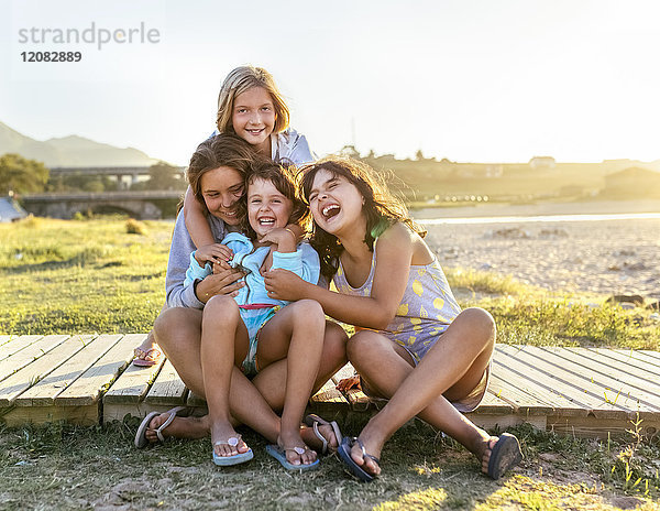Gruppenfoto von vier Mädchen an der Strandpromenade mit Spaß