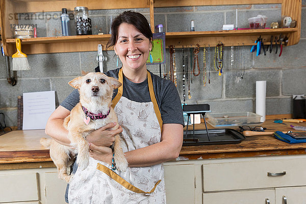 Porträt eines Schmuckherstellers und eines Haushundes  in der Werkstatt