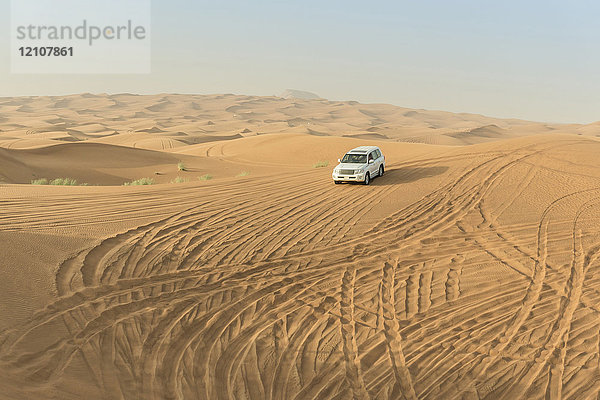 Geländewagen fährt durch Wüstendünen  Dubai  Vereinigte Arabische Emirate