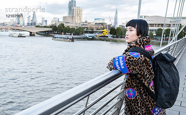 Stilvolle junge Frau  die von der Millennium-Fußgängerbrücke blickt  London  UK