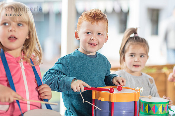 Kleine Kinder spielen mit Musikinstrumenten