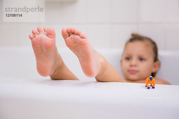 Mädchen mit hochgelegten Füßen entspannt in der Badewanne