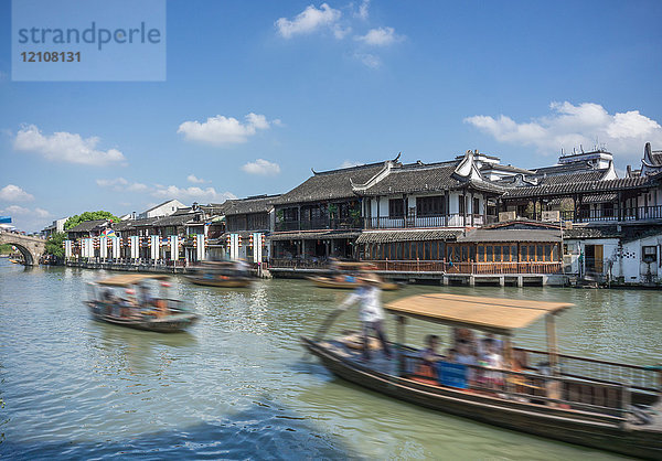 Flussschiffe auf dem Wasserweg mit traditionellen Gebäuden am Wasser  Shanghai  China