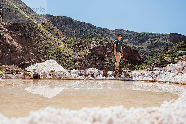 Mann erkundet Maras-Salzbergwerke  Cusco  Peru  Südamerika