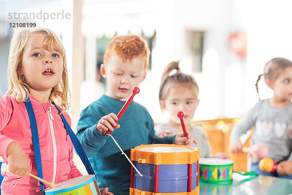 Kleine Kinder spielen mit Musikinstrumenten