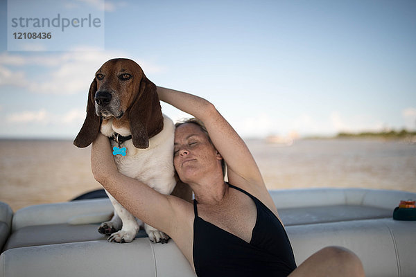 Frau und Haushund entspannen sich auf dem Boot