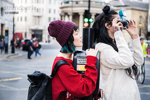 Zwei junge stilvolle Frauen fotografieren auf der Straße  London  UK