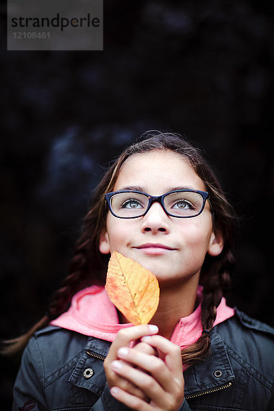 Bildnis eines Mädchens mit Zöpfen und Brille  das ein Blatt hält