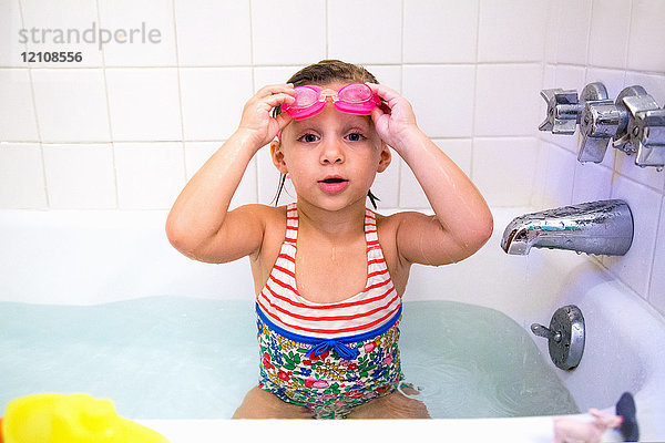 Porträt eines Mädchens mit Schwimmbrille in der Badewanne