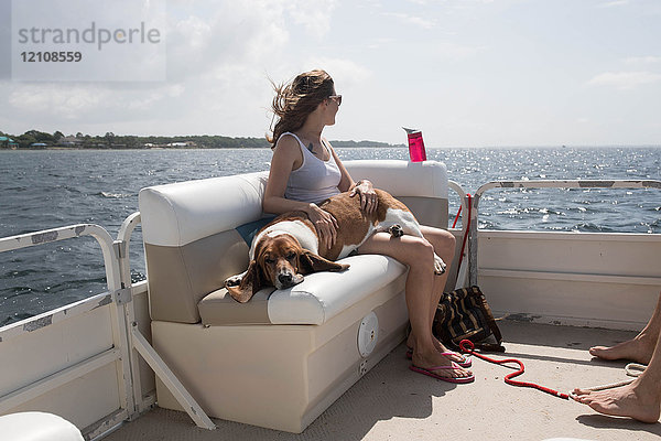 Frau und Haushund entspannen sich auf dem Boot