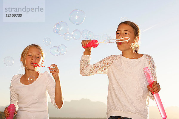 Zwei junge Mädchen  im Freien  die Blasen blasen