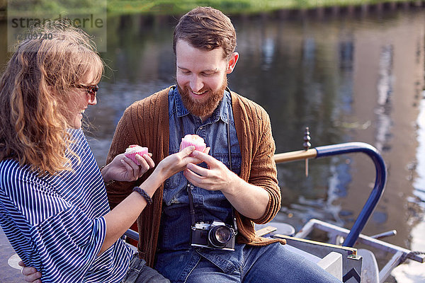 Ein Paar isst Muffins auf einem Kanalboot