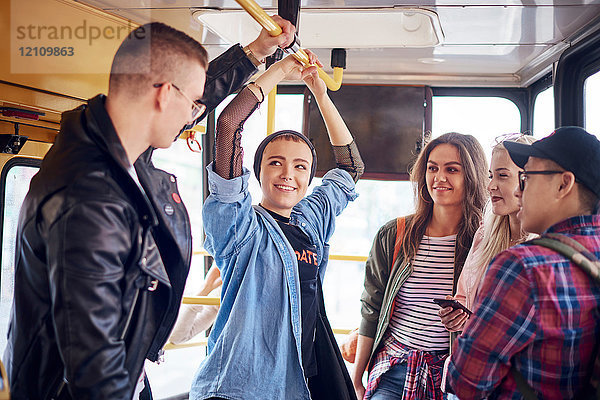 Fünf junge erwachsene Freunde unterhalten sich in der Stadtbahn