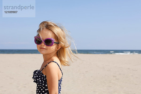 Porträt eines Mädchens am Strand mit Badeanzug und Sonnenbrille