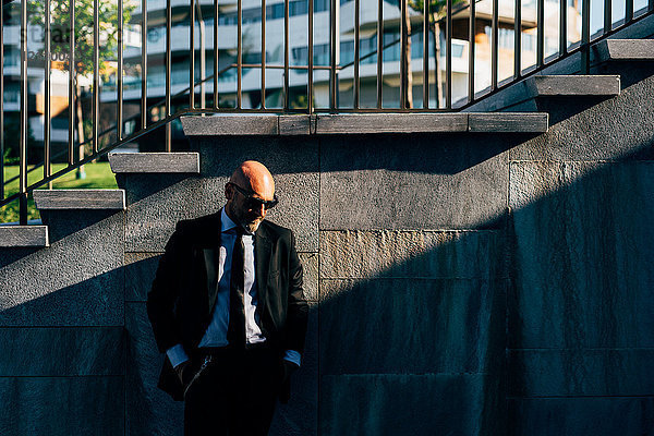 Porträt eines reifen Geschäftsmannes im Freien  neben Stufen stehend  nachdenklicher Ausdruck