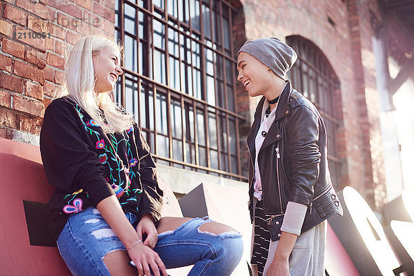 Zwei junge Freundinnen unterhalten sich auf der Straße in der Stadt