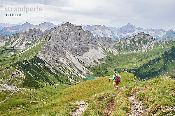 Rückansicht einer talabwärts wandernden Wanderin in den Tannheimer Bergen  Tirol  Österreich