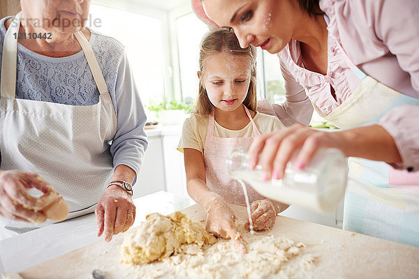 Mädchen  Mutter und Großmutter backen zu Ostern an der Küchentheke