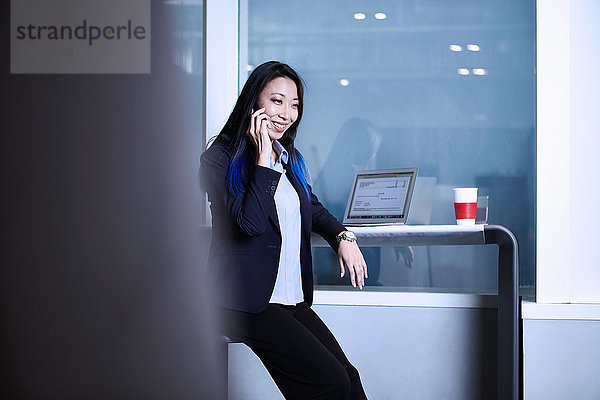 Geschäftsfrau benutzt Smartphone  telefoniert  lächelt