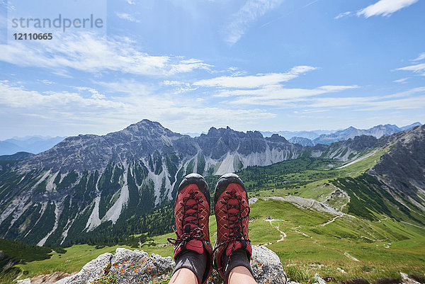 Persönliche Perspektive der Wanderstiefel einer Wanderin über dem Tal in den Tannheimer Bergen  Tirol  Österreich