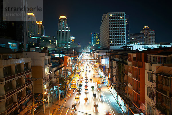 Stadtautobahnverkehr mit Wolkenkratzer-Skyline bei Nacht  Bangkok  Thailand