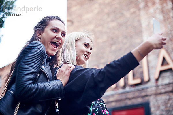 Zwei junge Frauen nehmen Smartphone-Selfie auf der Straße