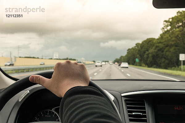 Mann fährt Auto auf dem Highway  Florida  USA  Nahaufnahme von Hand und Lenkrad