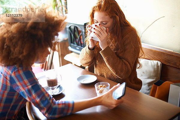 Freunde mit Smartphone entspannen sich im Cafe
