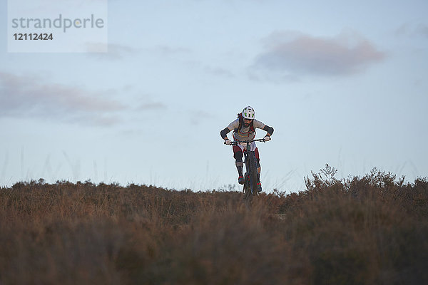 Männlicher Mountainbiker radelt durchs Moor
