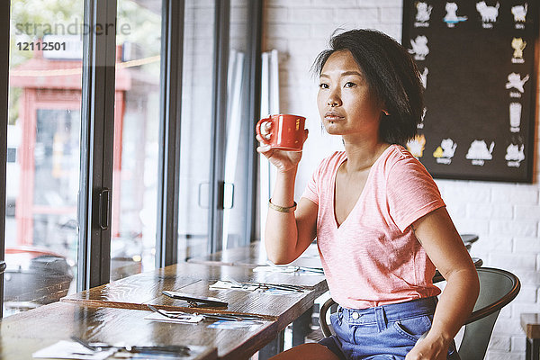 Frau im Café  die vom Fensterplatz aus zuschaut  Shanghai Französische Konzession  Shanghai  China