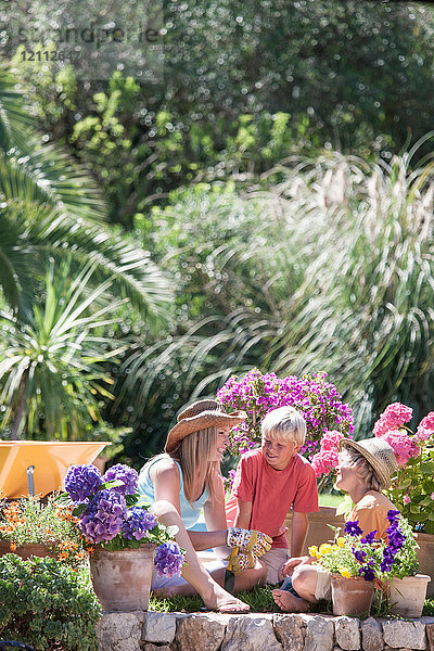 Mutter und Söhne bei der Gartenarbeit