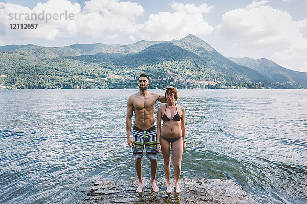 Porträt eines am Ufer des Comer Sees stehenden Paares in Badebekleidung  Lombardei  Italien