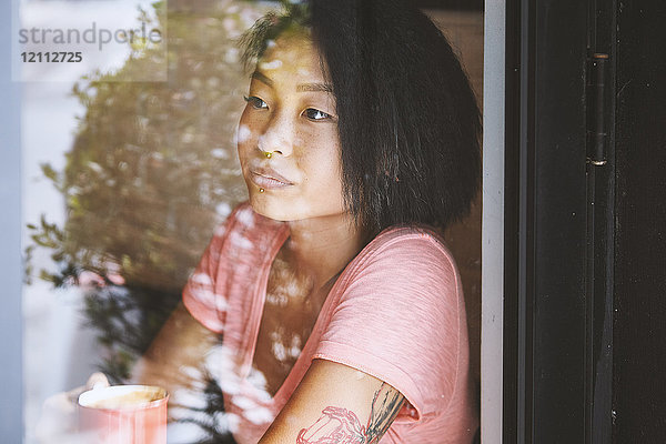 Frau blickt am Fensterplatz eines Cafés  Shanghai Französische Konzession  Shanghai  China