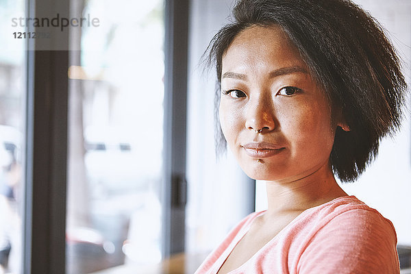 Porträt einer Frau mit Nasenpiercing in einem Cafe  Shanghai Französische Konzession  Shanghai  China