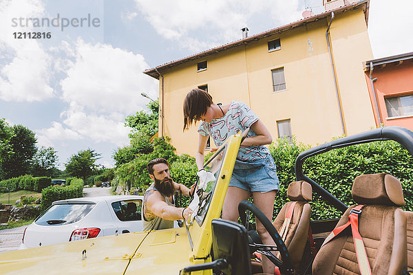 Junges Paar auf Autoreise reinigt Windschutzscheibe  Como  Lombardei  Italien