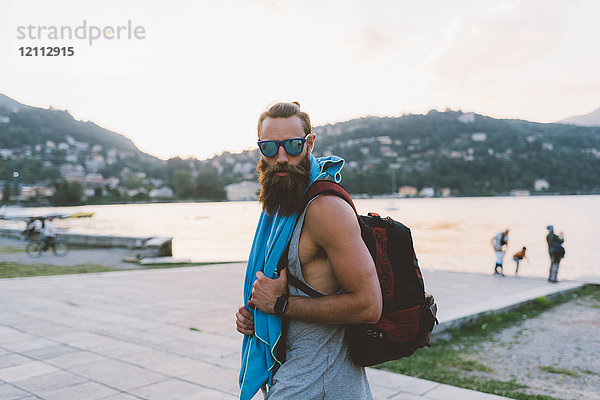 Porträt eines jungen männlichen Hipsters mit Rucksack am Comer See  Lombardei  Italien