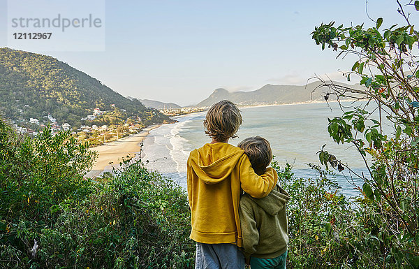 Jungen auf einer Klippe  die zum Strand wegschauen  Florianopolis  Santa Catarina  Brasilien  Südamerika