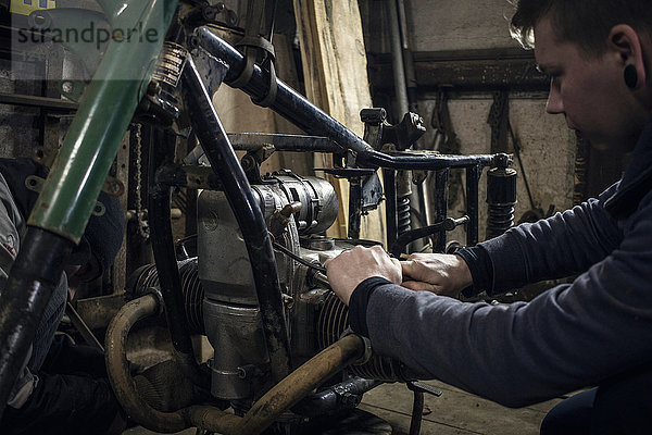 Mechaniker repariert Motorrad-Oldtimer in der Werkstatt