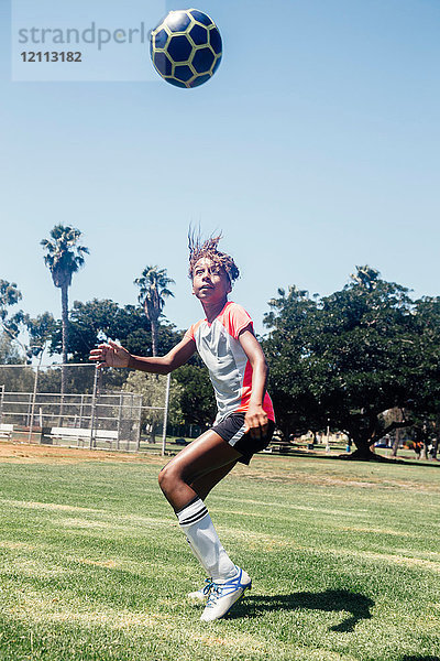 Teenager-Schülerin leitet Fussball auf Schulsportplatz