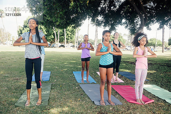 Mädchen und Teenager-Schülerinnen beim Üben von Yoga-Berghaltung auf dem Schulhof