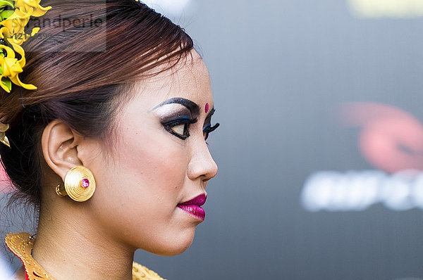 Porträt des Gesichts einer thailändischen jungen Frau mit Kosmetika und einer Frisur mit Blumen; Bali  Indonesien