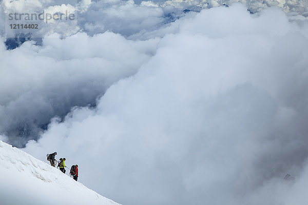 Bergsteiger beim Abstieg von der Aiguille du midi in die Wolken; Chamonix-Mont-Blanc  Haute-Savoie  Frankreich