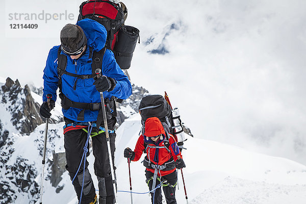 Bergsteiger mit Ausrüstung auf einem verschneiten Grat  Aiguille du midi; Chamonix-Mont-Blanc  Haute-Savoie  Frankreich